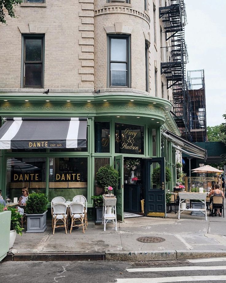 an outdoor cafe with tables and chairs on the sidewalk