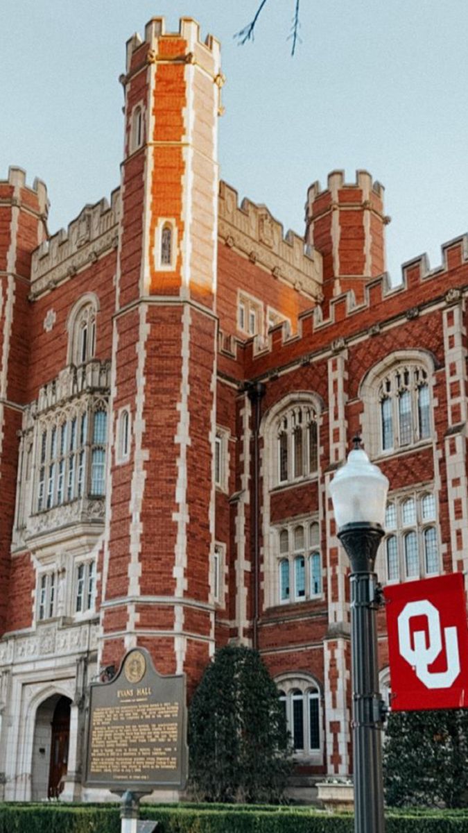 an old brick building with a clock tower on top and a red sign in front