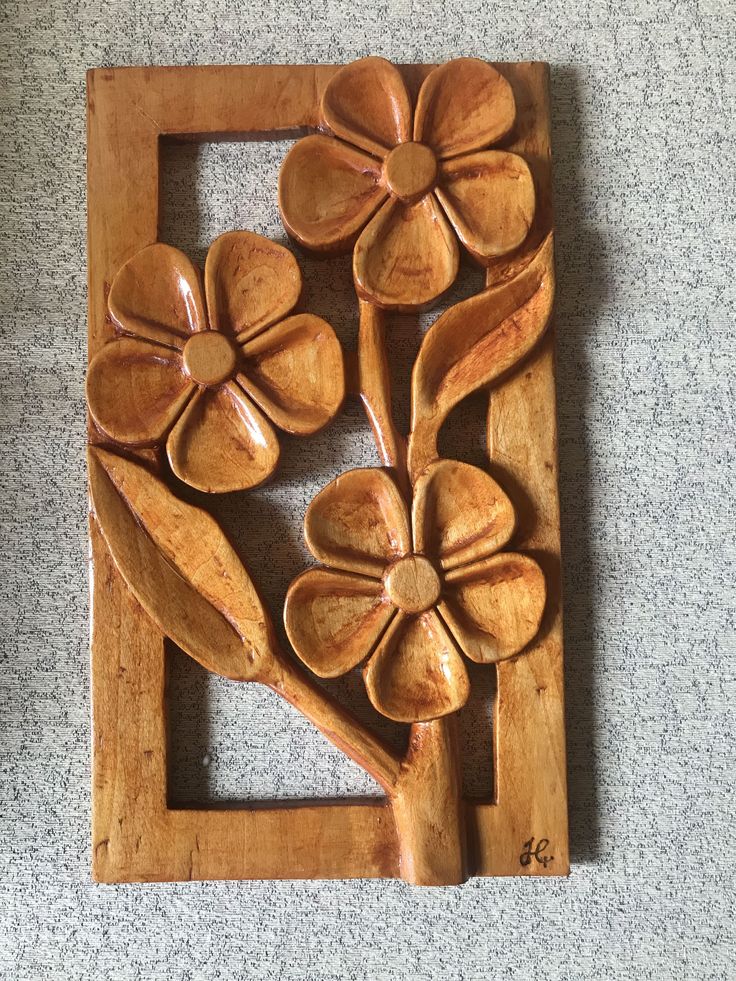 a wooden frame with flowers and leaves carved into it