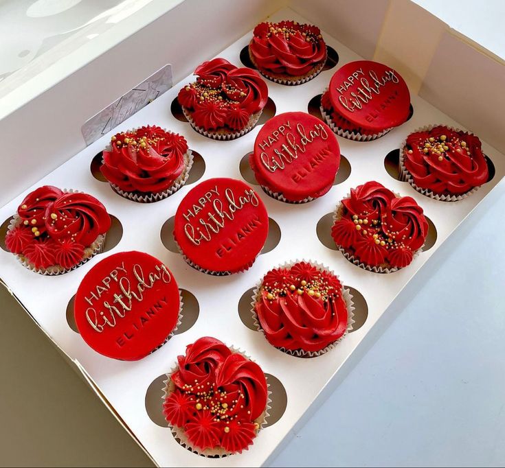 twelve red cupcakes in a white box with happy birthday written on the top