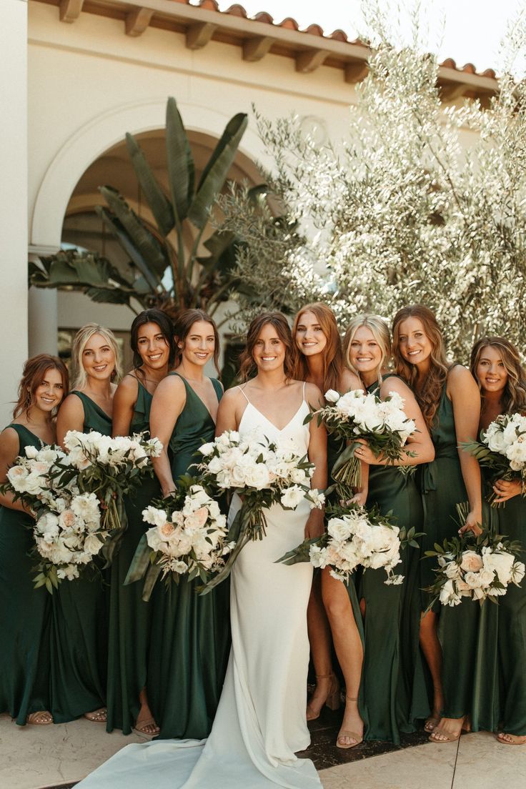 a group of women standing next to each other holding bouquets