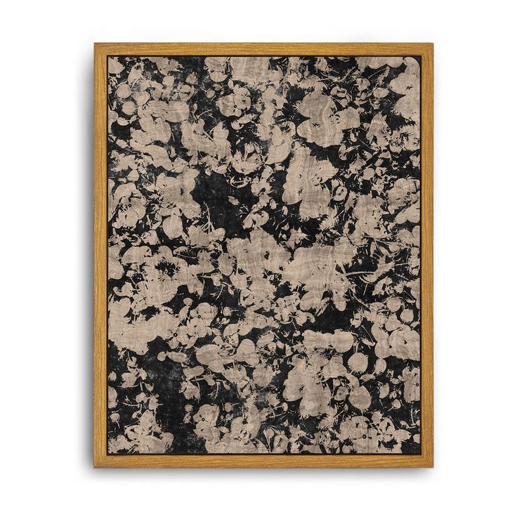 an abstract painting with black and white flowers in a wooden frame on a wall or floor