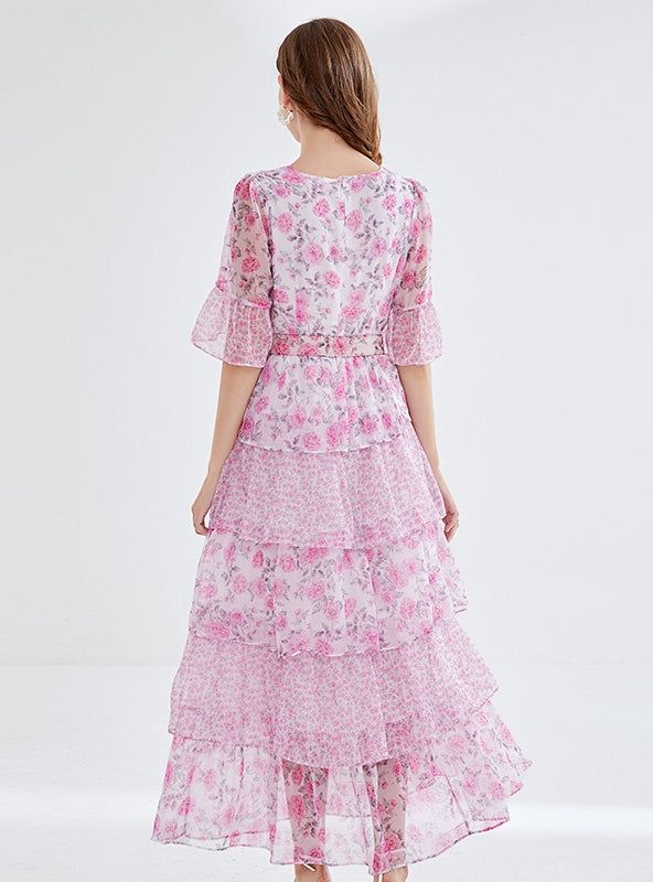 "Bathed in the soft blush of cherry blossoms, this enchanting tiered dress is a hymn to springtime romance. The delicate floral print weaves a narrative of blooming gardens and whispered tales of first love. Its graceful round neckline and sheer, breezy half-sleeves suggest an air of both demure charm and understated elegance. Cinched at the waist with an ornate rose buckle belt, the dress cascades down in ruffled layers, creating an ethereal sway with every step. This dress doesn't just capture Elegant Brunch, Printing Skirt, Leaf Cake, Chiffon Floral Dress, Springtime Wedding, Romantic Aesthetic, Cake Skirt, Wildflower Meadow, Sleeveless Dresses Casual