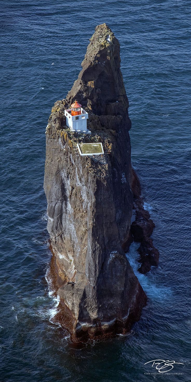 an island with a small house on it in the middle of the ocean