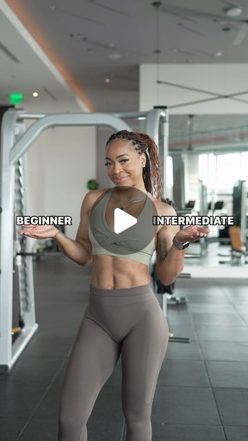 a woman in grey sports bra top and gray leggings standing next to a gym machine