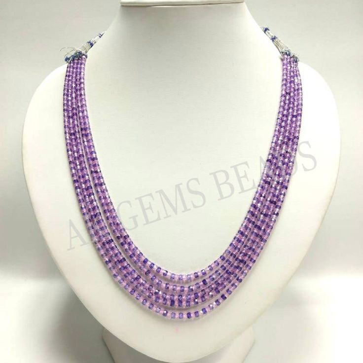 a purple beaded necklace on a white mannequin