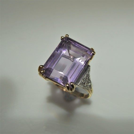 A beautiful natural untreated lilac colored earth mined amethyst and old cut diamond ring in 14K gold, 9.10 carats total weight. The central fine gem quality emerald cut amethyst weighs 9 carats, there is 0.10 carats of I clarity, G color old cut diamonds set into the shoulders. It is sizable. This ring is currently a 5 1/4 US.Inside the shank a 14K metal fineness stamp is present meaning solid 14K gold this confirmed too by testing. This ring rises high off the finger for a classic and luxuriou Engagement Ring Purple, 1950s Engagement Ring, Amethyst Birthstone Ring, Vintage Amethyst Ring, Lilac Amethyst, Amethyst Ring Vintage, Diamond Ring Vintage, Cascade Necklace, Amethyst Engagement Ring