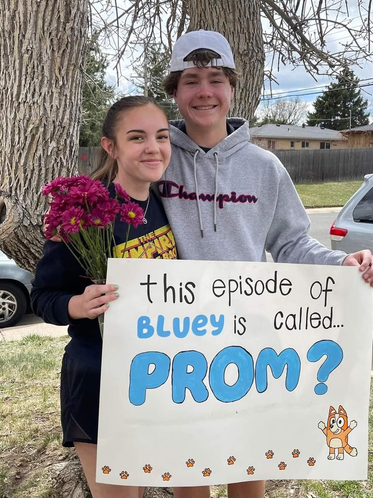 a boy and girl holding a sign that says, bluey is called prom?