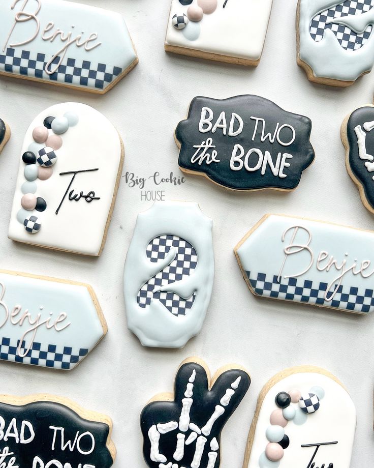 decorated cookies are arranged on a table with black and white designs, including the words bad to the bone