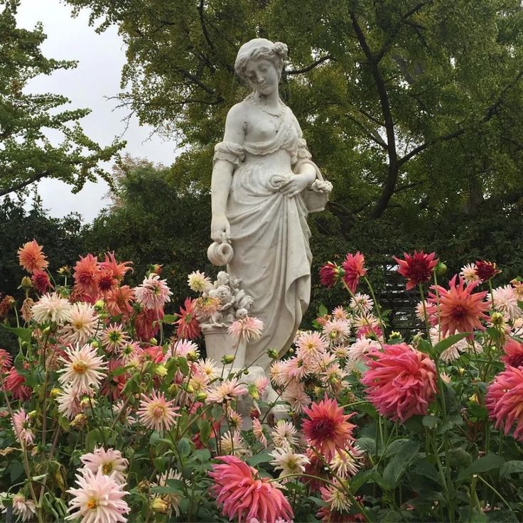 there is a statue in the middle of flowers