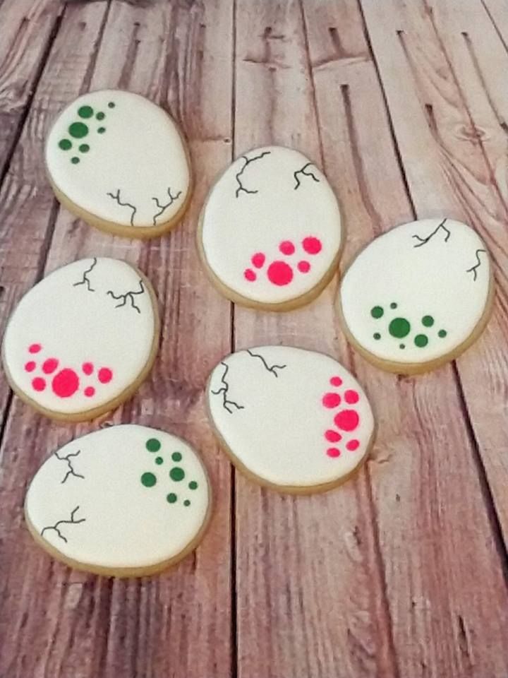 six decorated cookies sitting on top of a wooden table