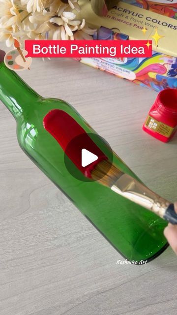 someone is painting the bottom of a green bottle