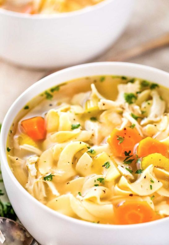 two white bowls filled with chicken noodle soup