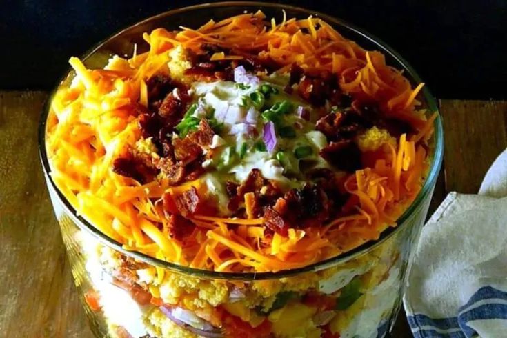 a large glass bowl filled with food on top of a wooden table