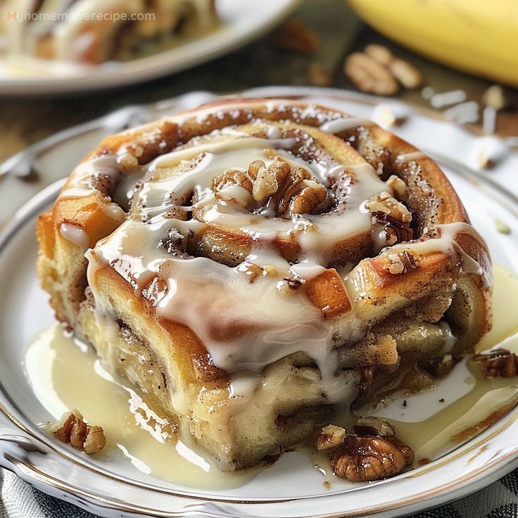 a cinnamon roll with icing and nuts on a plate