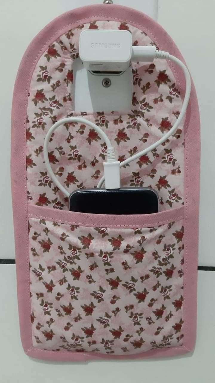 an electronic device is plugged in to a pink flowered bag with a charger attached