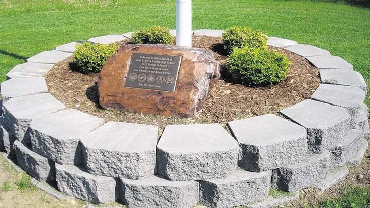 a sign is placed in the middle of a stone circle with a flag on it