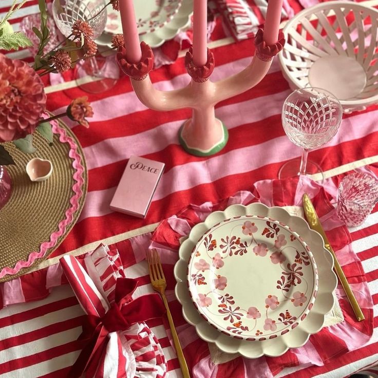 the table is set with pink and white plates