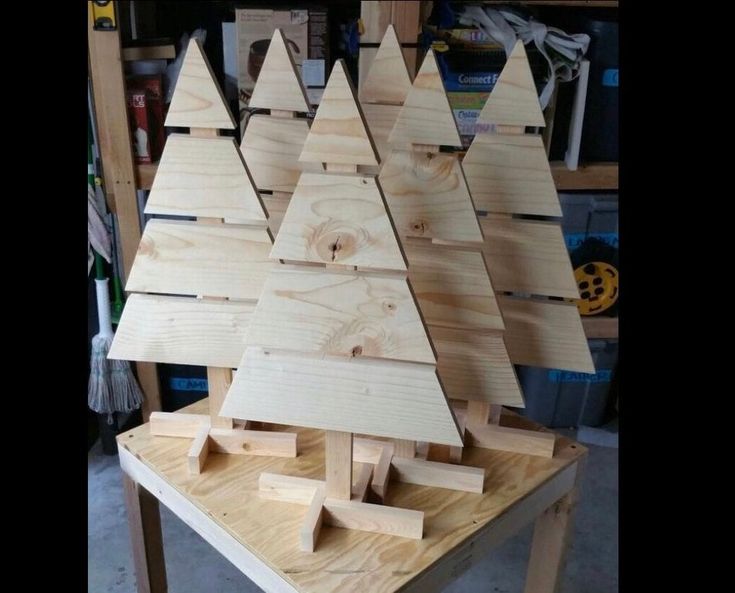 a wooden christmas tree sitting on top of a table in a room filled with tools