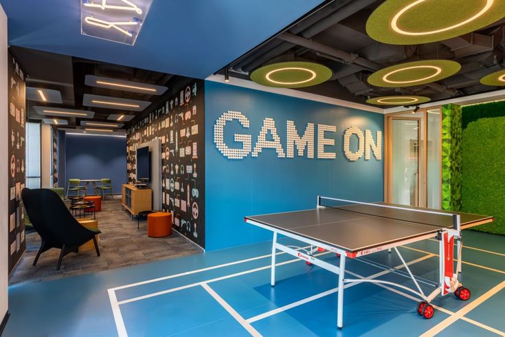 a ping pong table sitting in front of a game room wall with the word game on it