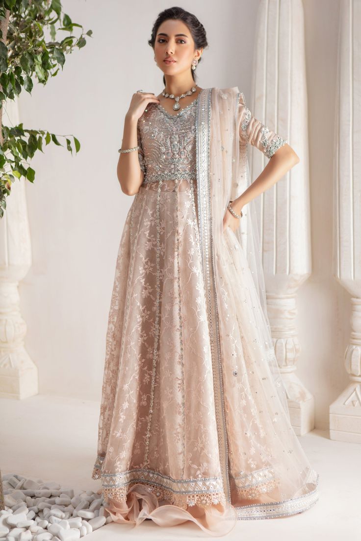 Step up your festive dressing game with our beautifully crafted kalidar over a canvas of stunning embroidered organza, heavily embellished with sequins, beads, crystals, neckline and sleeves beautifully adorned with gorgeous zardozi, mirror work & Resham thread work. Stunning hand-made stylized tassel details at back. This stunning multi panel kalidar is offset with jamawar Lehanga with gorgeous ruffle details & net dupatta featuring sequins & mirror motifs and chan, trimmed with mirror embroidered borders , a Must- have wardrobe staple to carry all Wedding Festivities in effortless style. Shirt Fabric: Pure embroidered Organza & Silk Net Lehanga Fabric: Jamawar Dupatta Fabric: French Net Color: Shell Pink This outfit is only available in Custom size, once order is placed design team will Reception Anarkali Set With Dabka Work For Navratri, Embroidered And Embellished Fabric For Designer Wear During Navratri, Anarkali Choli With Dabka Work In Chanderi, Anarkali Party Set With Mirror Work, Kundan Anarkali Dress For Wedding, Semi-stitched Kundan Gown With Intricate Embroidery, Resham Embroidered Anarkali Set For Reception, Chandbali Anarkali Set With Mirror Work For Reception, Unstitched Embellished Raw Silk Anarkali Set