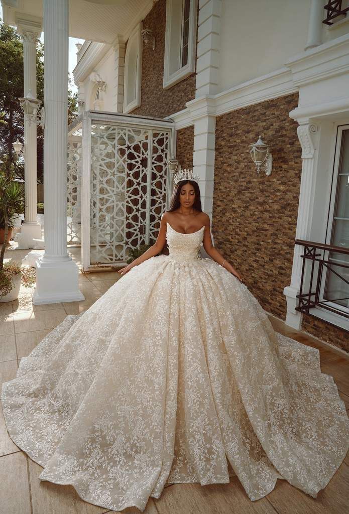 a woman in a ball gown standing on the porch with her hands on her hips