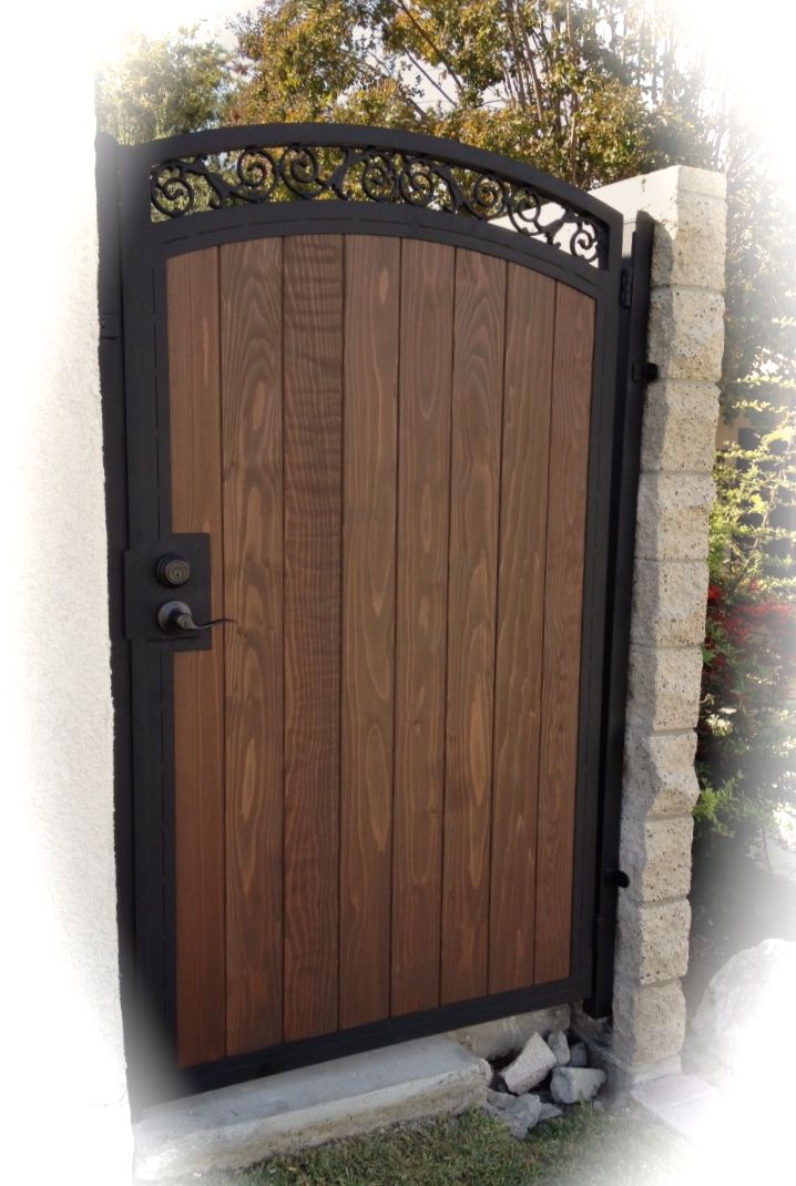 a wooden gate with wrought iron work on it