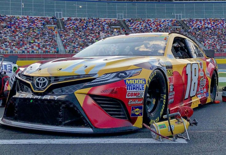 a car that is sitting on the ground in front of a crowd at a race