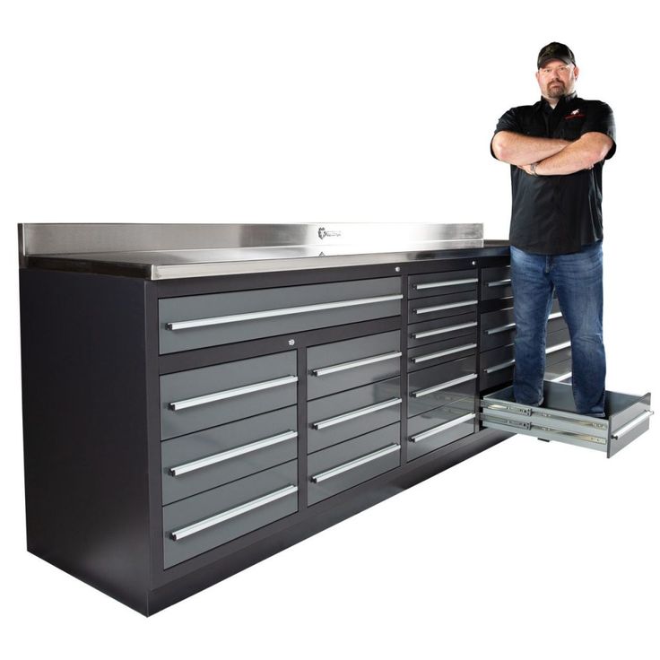 a man standing next to a metal workbench