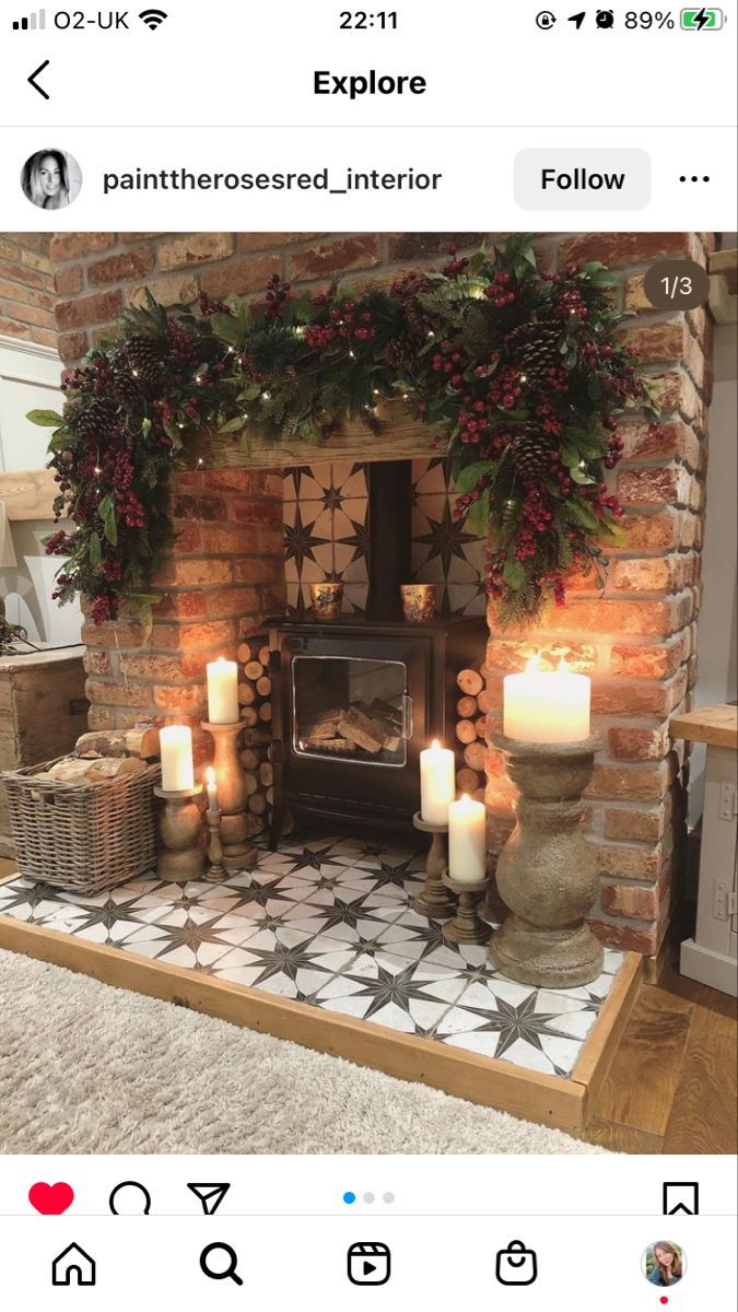 a decorated fireplace with candles and wreaths on the mantel in front of it