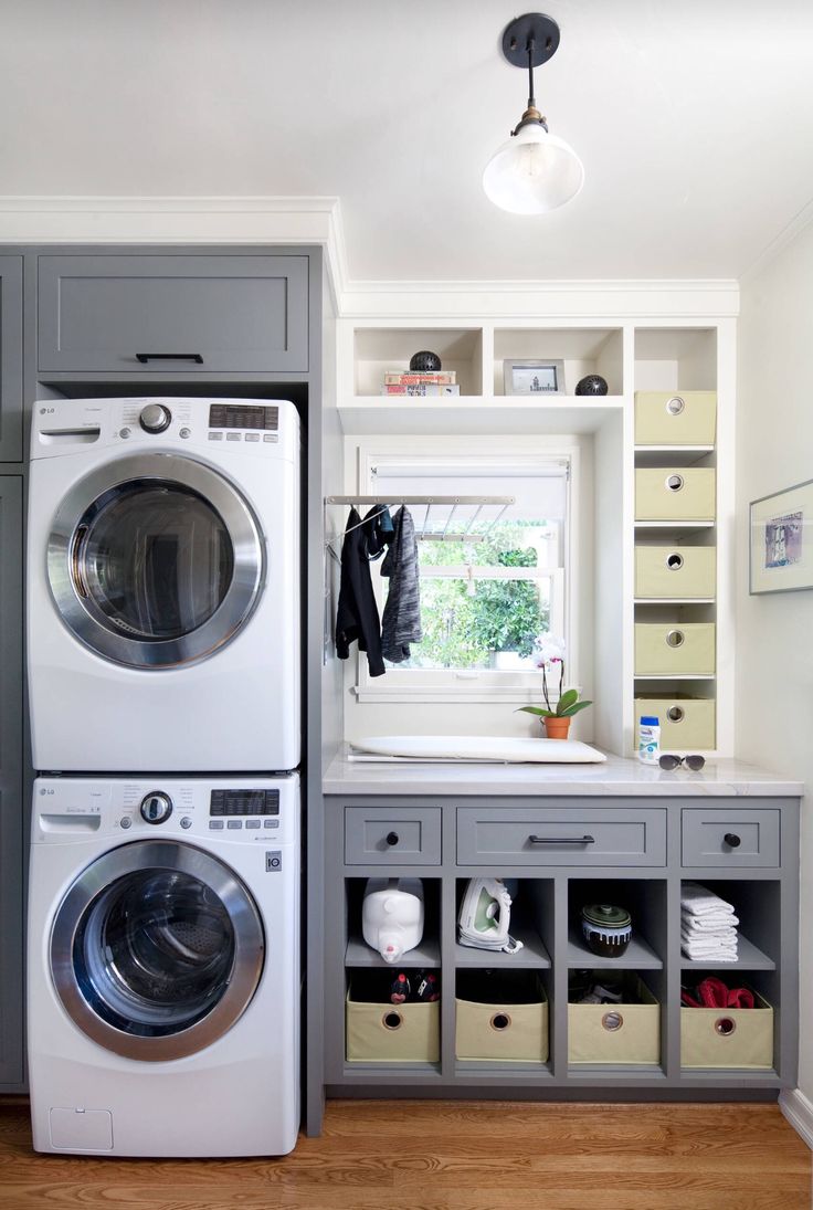 a washer and dryer in a small room with built - in shelving