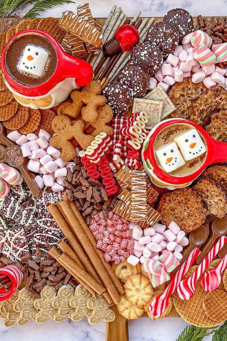 a platter filled with cookies, marshmallows and other holiday food items