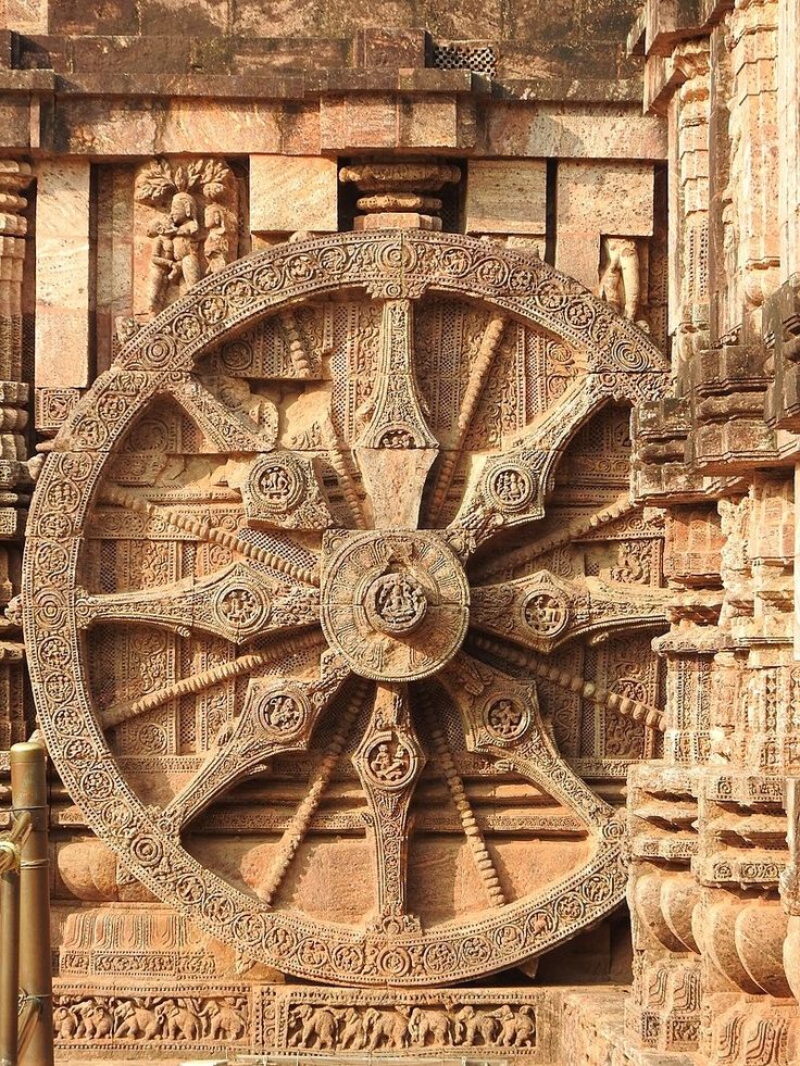 an intricately carved wheel on the side of a building