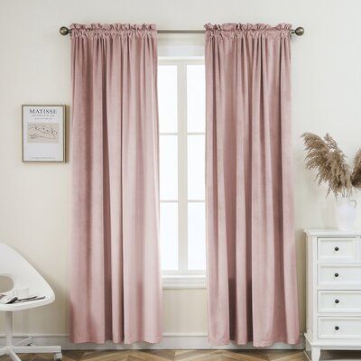 a pink curtain hanging in front of a window with white furniture and decor on the floor