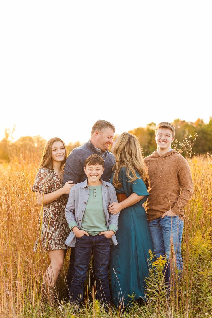 a family posing for a photo in the tall grass