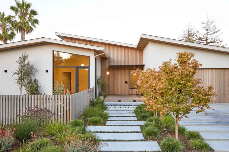 a house with steps leading up to the front door and trees in the back yard