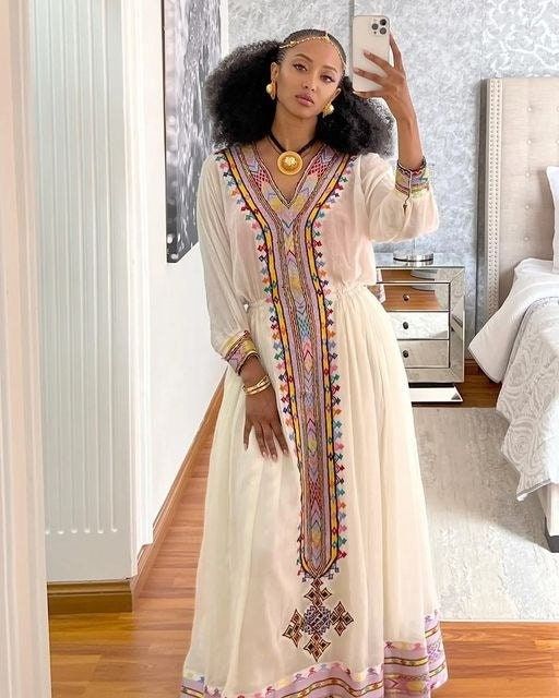 This Habesha Kemis is a true work of art, designed to make you stand out in any crowd. The dress features handwoven Tilf fabric in a beautiful and intricate pattern, adding a touch of elegance and sophistication. The Shimena fabric on the bodice and sleeves is smooth and soft, making it comfortable to wear all day or night. The dress is tailored to fit your body perfectly, with a flowy bottom that adds a touch of grace and femininity. Whether you're attending a wedding, a cultural festival, or a African Dress Patterns, Eritrean Clothing, Eritrean Dress, Ethiopian Wedding, Ethiopian Clothing, Ethiopian Traditional Dress, Ethiopian Dress, Habesha Kemis, Fashion Hacks Clothes