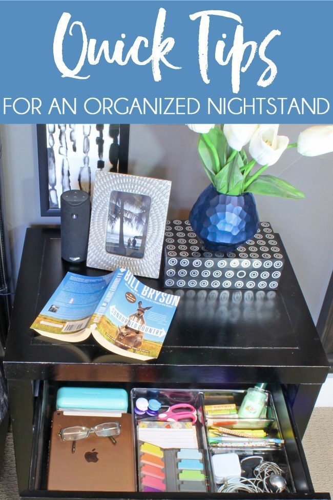 an organized night stand with books, magazines and other items on it that are sitting on top of a black table