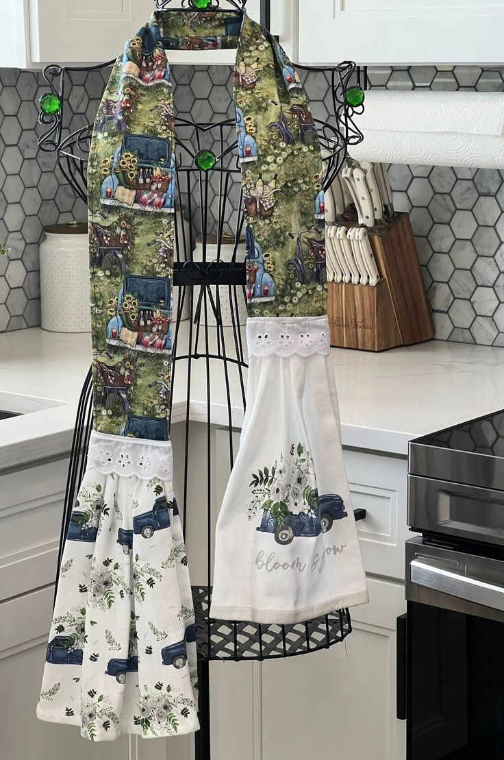 two aprons hanging on a rack in a kitchen