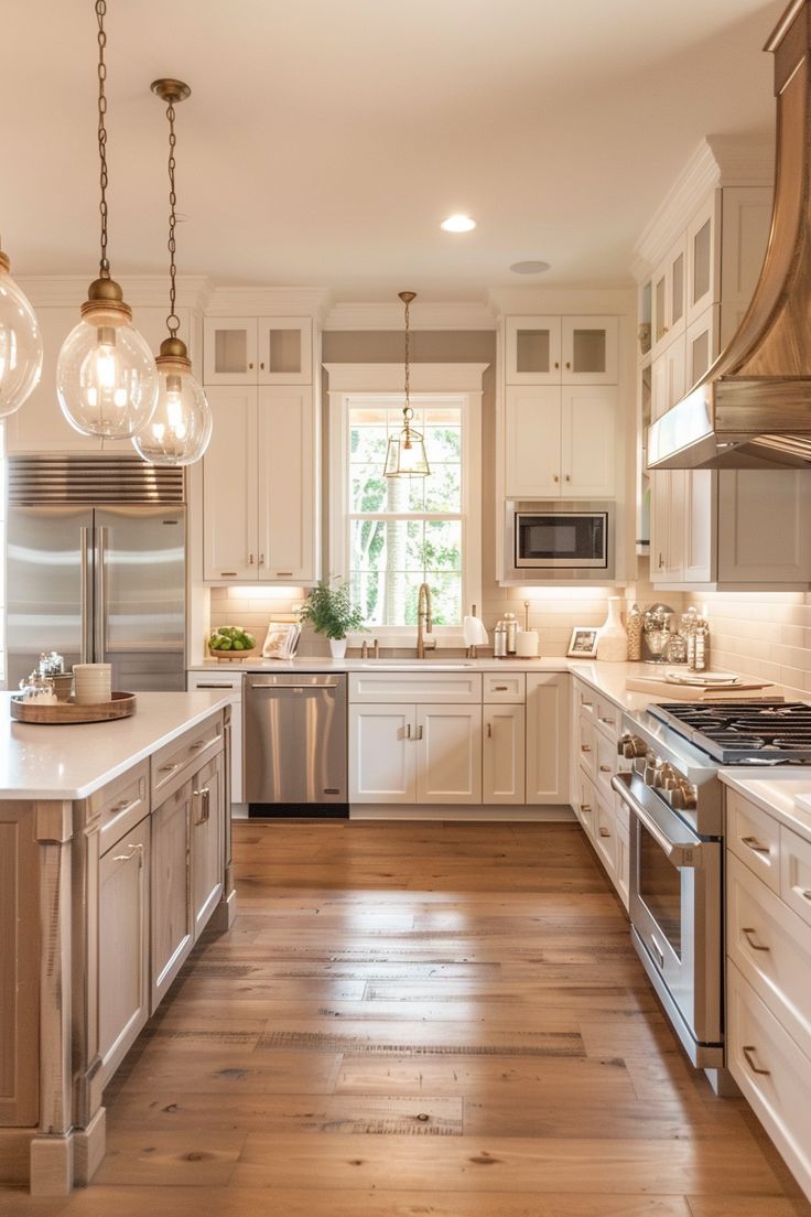 a large kitchen with white cabinets and wood flooring, lights hanging from the ceiling