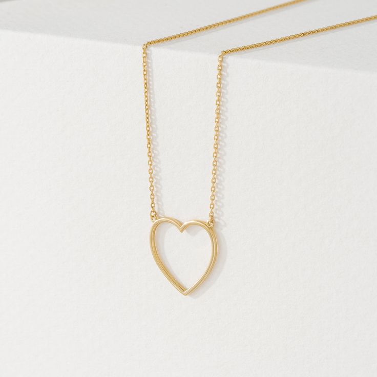 Anabella Follow your heart and it’ll lead you to our 14k gold necklaces. Add a touch of timeless elegance with our delicate Heart Cut-Out Pendant in Solid Gold. This beautiful pendant features a classic heart shape with a modern open center design. Crafted from 14k solid gold (available in yellow, white, or rose gold), this pendant offers long-lasting quality and a luxurious shine. Its versatility makes it perfect for any outfit, and it's a thoughtful gift symbolizing love and affection. - Handm