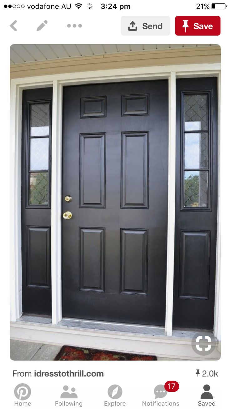 a black front door with two sidelights and a rug on the ground in front of it