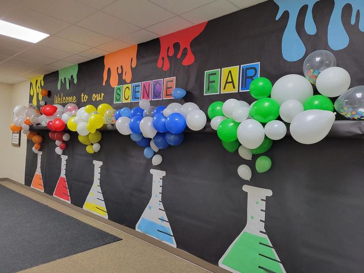 an office hallway decorated with colorful balloons and science themed wall art for the school year