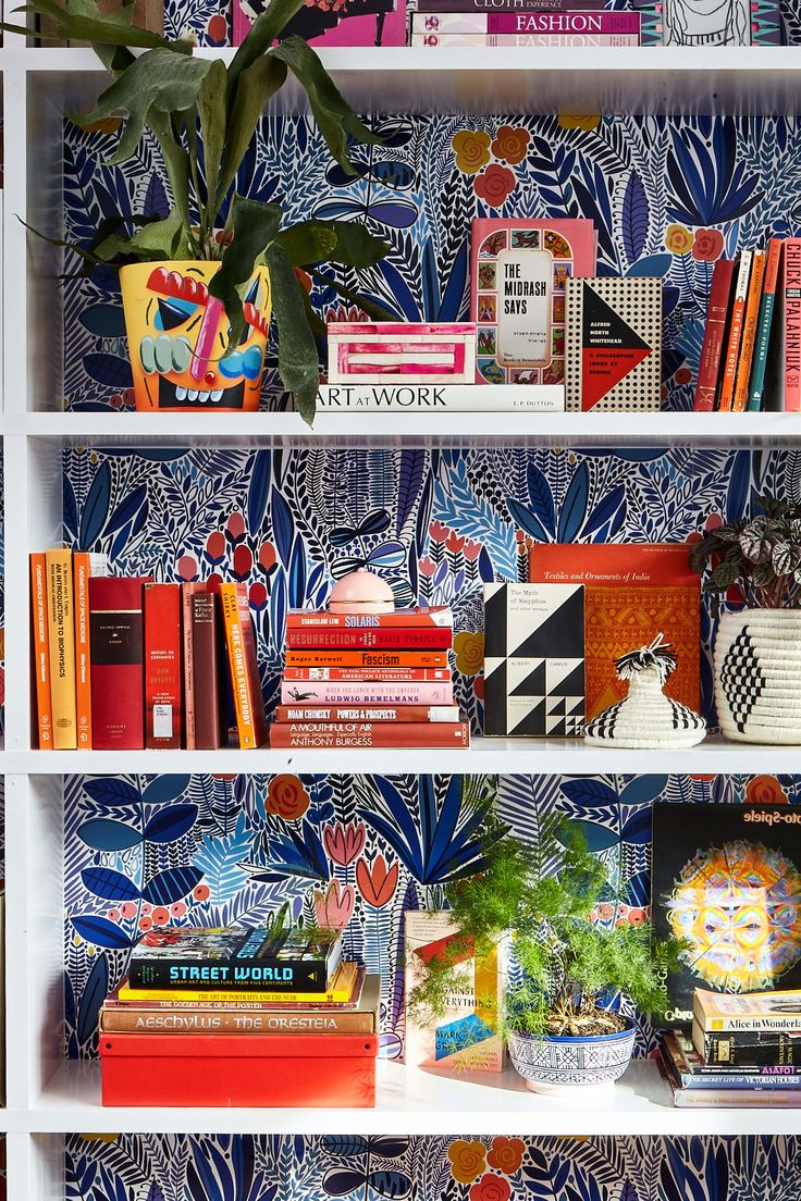 the bookshelf is filled with many different types of books and vases on it