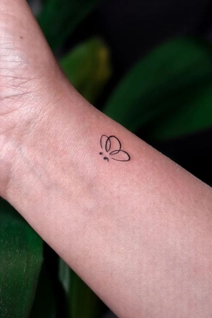 a person's arm with a small tattoo on it