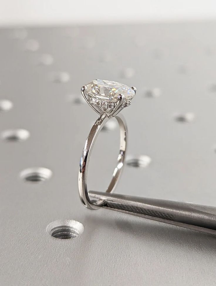 a diamond ring sitting on top of a metal surface