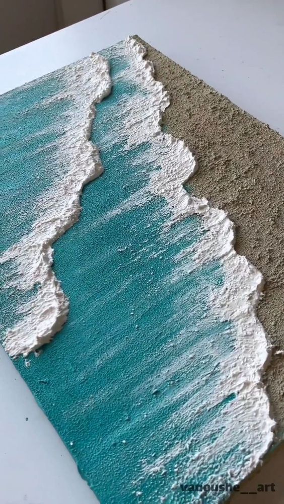 a piece of art that looks like waves crashing on the beach with sand and sea foam