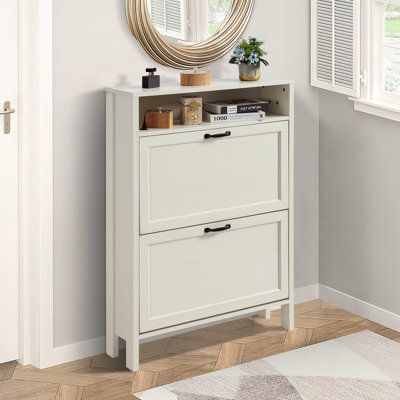 a white cabinet with drawers and a round mirror on the wall above it in a room