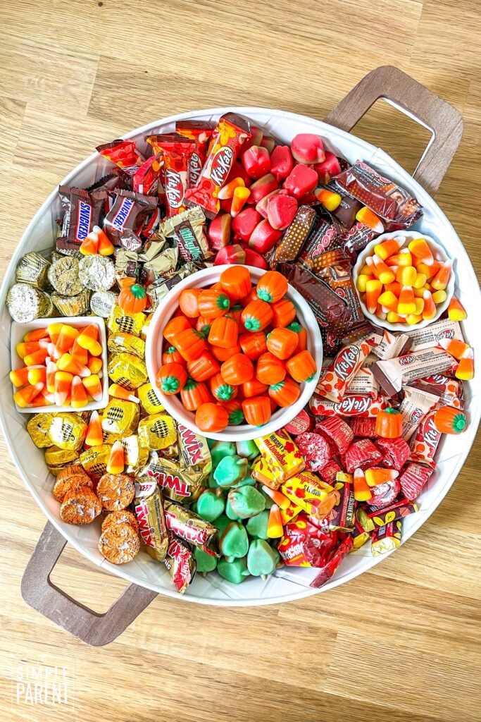 a platter filled with candy and candies on top of a wooden table,