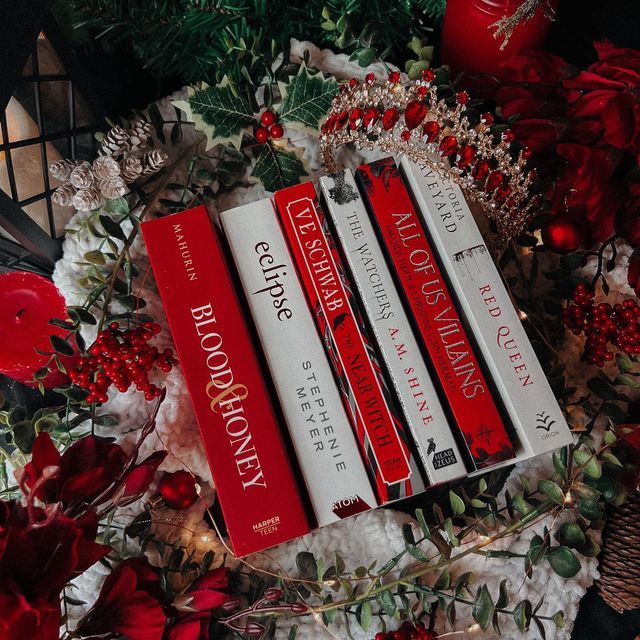 three red books sitting on top of a christmas wreath